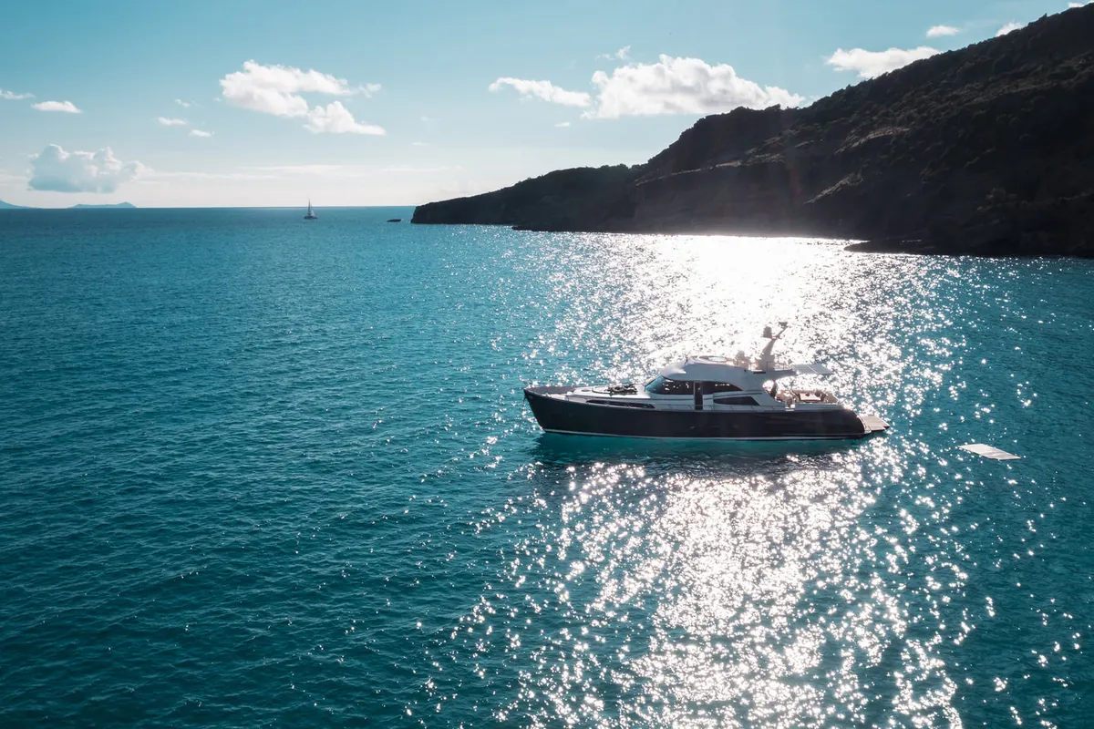 Mochi 74 motor yacht in a St Barth cove at golden hour